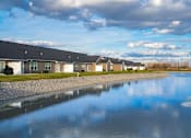 Thumbnail 23 of 23 - A row of houses with a body of water in front of them.