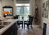 Thumbnail 11 of 20 - A kitchen with a table and chairs and a Christmas tree.