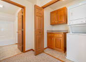 Thumbnail 8 of 14 - A white oven and dishwasher in a kitchen with wooden cabinets.