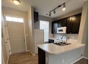 Thumbnail 14 of 20 - A kitchen with a white counter top and black cabinets.