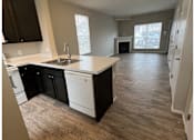 Thumbnail 13 of 20 - A kitchen with black cabinets and white appliances.