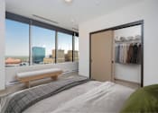 Thumbnail 4 of 34 - A bedroom with a large bed and a view of the city.