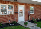 Thumbnail 16 of 16 - A brick house with a white door and a mailbox.