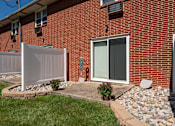 Thumbnail 10 of 16 - A red brick house with a white fence and a glass door.