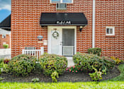 Thumbnail 16 of 17 - A red brick building with a black awning and a white door.
