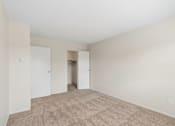 Thumbnail 13 of 17 - A room with a carpeted floor and two doors.