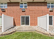 Thumbnail 7 of 17 - A red brick house with a white fence and a black door.