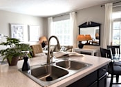 Thumbnail 10 of 20 - A kitchen with a sink and a mirror.