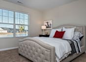 Thumbnail 15 of 23 - A bedroom with a large bed and a window with blinds.