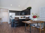 Thumbnail 8 of 23 - A kitchen with a table and chairs in the middle of the room.