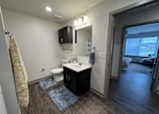 Thumbnail 9 of 19 - A bathroom with a toilet, sink, and mirror.