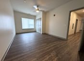Thumbnail 6 of 19 - A room with wooden flooring and a ceiling fan.