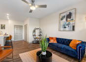 Thumbnail 2 of 62 - a living room with a blue couch and a ceiling fan at 41 North Apartments, Fort Wayne, IN