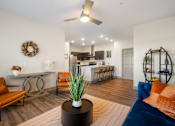 Thumbnail 23 of 62 - a living room with a couch and a table with a kitchen in the background at 41 North Apartments, Fort Wayne
