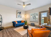 Thumbnail 14 of 62 - a living room with a blue couch and a ceiling fan at 41 North Apartments, Fort Wayne, IN 46835