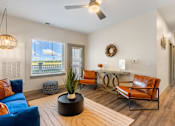 Thumbnail 3 of 62 - a living room with a blue couch and chairs and a desk with a window at 41 North Apartments, Fort Wayne, 46835