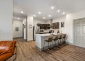 Thumbnail 20 of 62 - a kitchen and living room with an island and bar stools at 41 North Apartments, Fort Wayne, IN