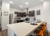 Thumbnail 36 of 62 - a kitchen with a large island and a stainless steel refrigerator at 41 North Apartments, Fort Wayne Indiana