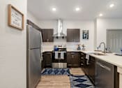 Thumbnail 17 of 62 - an open kitchen with stainless steel appliances and a refrigerator at 41 North Apartments, Fort Wayne