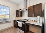 Thumbnail 26 of 62 - an updated kitchen with black appliances and wooden cabinets at 41 North Apartments, Fort Wayne, IN 46835