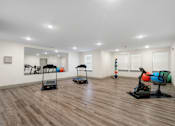 Thumbnail 39 of 62 - a gym with treadmills and weights in a room with white walls and floors at 41 North Apartments, Indiana, 46835