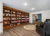 Thumbnail 13 of 62 - a library with a black leather chair and a book shelf at 41 North Apartments, Indiana, 46835