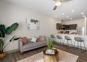 Thumbnail 51 of 62 - a living room with a couch and a kitchen with a bar at 41 North Apartments, Indiana, 46835