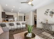 Thumbnail 41 of 62 - a living room with a kitchen with a bar and a ceiling fan at 41 North Apartments, Fort Wayne, IN