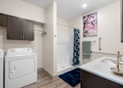 Thumbnail 31 of 62 - a white washer and dryer in a bathroom with a shower and a sink at 41 North Apartments, Indiana