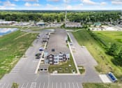 Thumbnail 58 of 62 - an aerial view of a parking lot with a building and a field and a lake at 41 North Apartments, Indiana, 46835