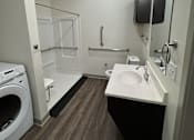 Thumbnail 10 of 19 - A small bathroom with a washer and dryer.