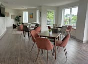 Thumbnail 15 of 19 - A dining room with a long table and chairs.