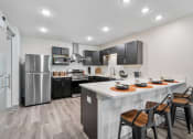 Thumbnail 22 of 43 - redesigned kitchen with stainless steel appliances and a large island with stools at Morada at Maysville, Fort Wayne, IN 46815