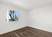 Thumbnail 38 of 40 - Empty room with a window showing a tree outside.