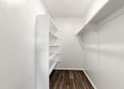 Thumbnail 39 of 40 - A long hallway with shelves on the side and a wooden floor.
