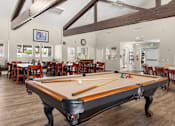 Thumbnail 24 of 40 - A pool table is in the middle of a room with a bar and dining area.