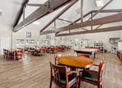 Thumbnail 23 of 40 - A large room with tables and chairs and a wooden ceiling.