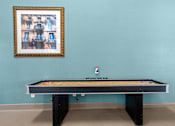 Thumbnail 25 of 40 - A pool table with a picture frame on the wall.