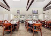 Thumbnail 22 of 40 - A dining room with a long table and chairs.