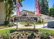 Thumbnail 3 of 40 - A sign for Heritage Park Mature Adult Apartments is displayed in front of a building.