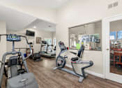 Thumbnail 27 of 40 - A home gym with a treadmill, elliptical trainer, and stationary bike.