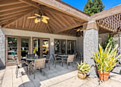 Thumbnail 17 of 40 - A patio with a table and chairs under a roof.
