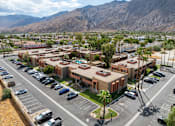Thumbnail 6 of 16 - A parking lot with cars and a building in the background.