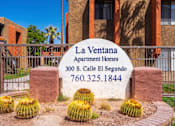 Thumbnail 1 of 16 - A sign for La Ventana Apartment Homes stands in front of a building.