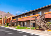 Thumbnail 9 of 16 - A row of apartment buildings with a mountain in the background.
