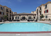 Thumbnail 6 of 50 - A swimming pool in front of apartment buildings.