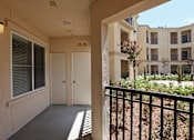 Thumbnail 28 of 50 - A balcony with a black railing and a view of a building with windows and balconies.