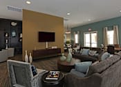 Thumbnail 11 of 50 - A living room with a grey couch, a grey armchair, a coffee table, and a brown sofa.
