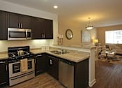 Thumbnail 30 of 50 - A modern kitchen with dark wood cabinets and stainless steel appliances.