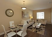 Thumbnail 39 of 50 - A living room with a glass table and white chairs.